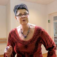 Märchenerzählerin Silvia Knapp im roten Kleid spricht die Zuhörer direkt an